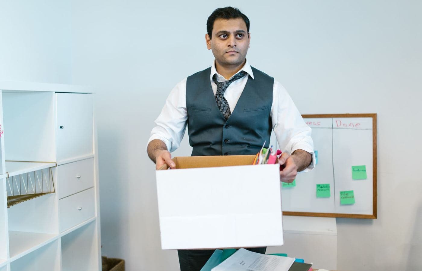 A man carrying a box of belongings out of an office