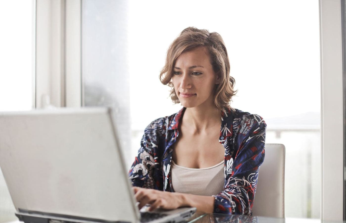 A woman working on her laptop at a desk